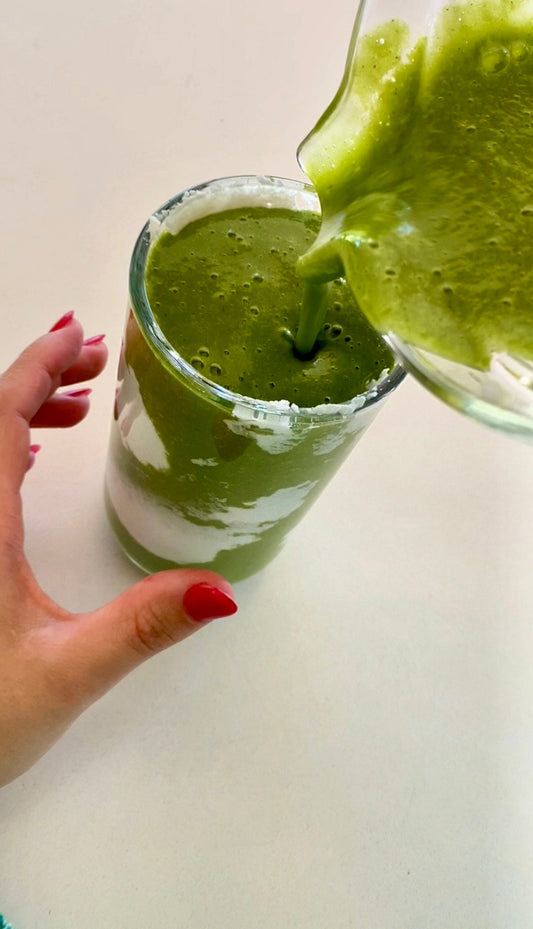 green smoothie being poured into a glass
